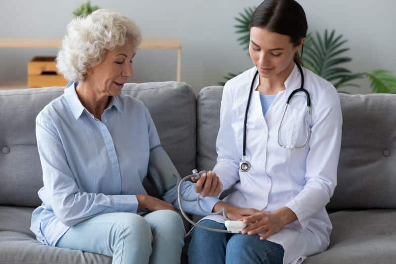 Nurse taking blood pressure of patient